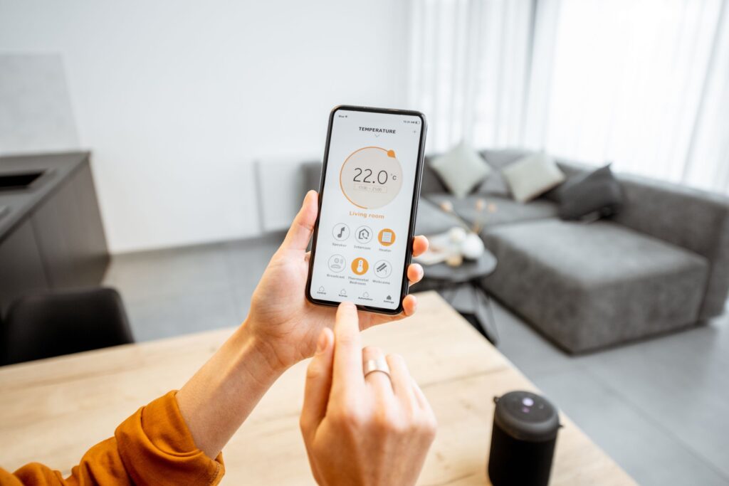 Controlling home heating temperature with a smart home, close-up on phone.